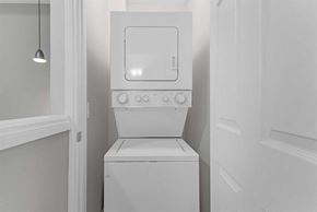 Calgary apartment for rent - A white microwave oven is built into a cabinet.
