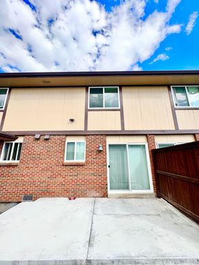 Lakewood apartment for rent - A house with a brown brick wall and a tan siding wall with a glass door and window.
