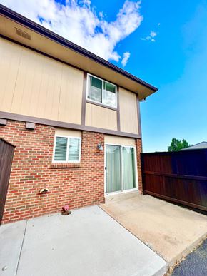 Lakewood apartment for rent - A house with a brown brick wall and a green door.