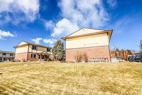 Lakewood apartment for rent - A large building with a grassy field in front of it.