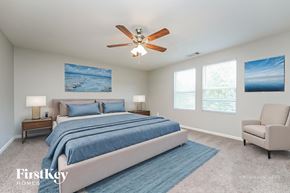 Bethlehem house for rent - A bedroom with a large bed, a ceiling fan, and two pictures on the wall.