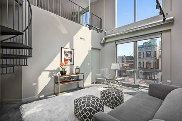 Chicago apartment for rent - A living room with a grey sofa and a black and white ottoman.
