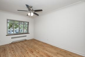 Denver apartment for rent - A room with a ceiling fan and a window with a view of a building outside.
