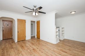 Denver apartment for rent - A room with a ceiling fan and wooden floors.