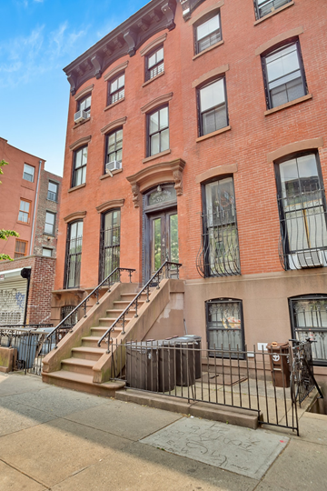 Brooklyn apartment for rent - A red brick building with a staircase leading to the front door.