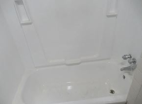 Bedford apartment for rent - A white bathtub with a faucet and handles.