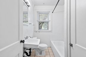 Denver apartment for rent - A white bathroom with a toilet, sink, and bathtub.