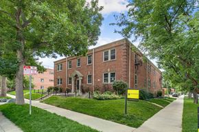 Denver apartment for rent - A red brick building with a sign in front of it.