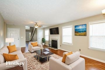 Antioch house for rent - A living room with a fireplace and a painting of a beach scene on the wall.