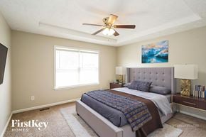 Antioch house for rent - A bedroom with a bed, a ceiling fan, and a painting on the wall.