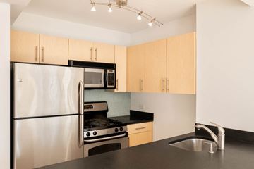 New York apartment for rent - A kitchen with a refrigerator, microwave, oven, and sink.