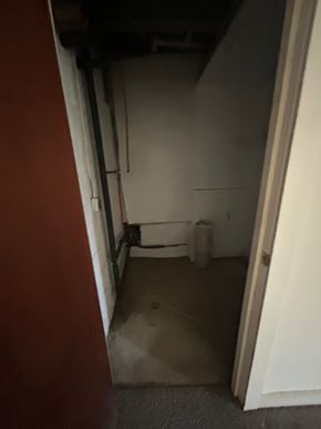 Laurys Station apartment for rent - A dirty, unfinished basement with a white toilet.