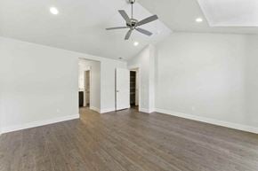 Bend apartment for rent - A spacious room with a ceiling fan and wooden flooring.