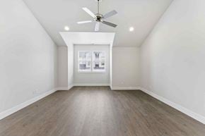 Bend apartment for rent - A room with a ceiling fan and a window with a view of a building.