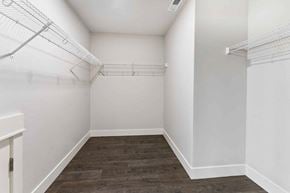 Bend apartment for rent - A walk-in closet with white shelving and a wooden floor.