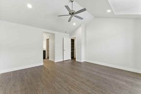 Bend apartment for rent - A spacious room with a ceiling fan and wooden flooring.