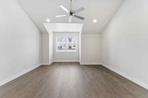 Bend apartment for rent - A room with a ceiling fan and a window with a view of a building.