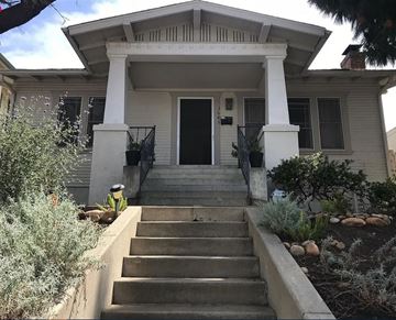 San Diego house for rent - A white house with a black door and steps leading up to it.