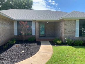 Crestview house for rent - A house with a grey roof and a gravel area in front.