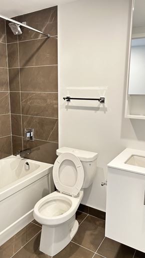 Toronto apartment for rent - A white toilet in a tiled bathroom.