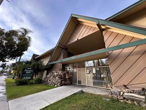 Anaheim apartment for rent - A building with a sign that says "Pine Ridge Apartments" in front of it.