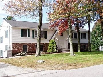 Derry apartment for rent - A house with a white and grey exterior and a green lawn.