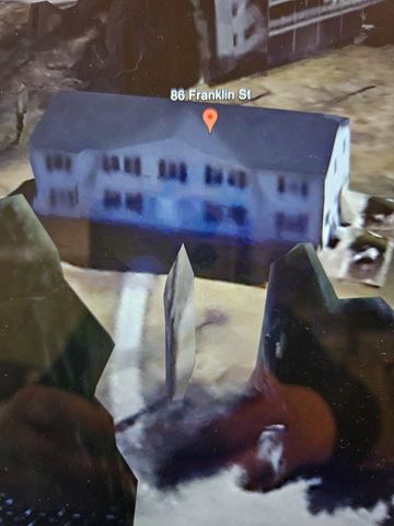 Derry apartment for rent - A person is holding a knife in front of a building with a sign that reads 86 Franklin St.