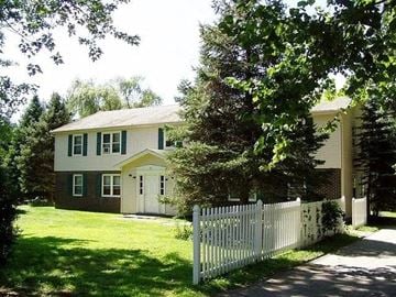 Derry apartment for rent - A white picket fence surrounds a two-story house.