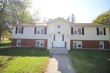 Derry apartment for rent - A two-story house with a white door and a porch.