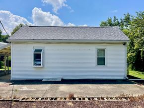 New Albany house for rent - A small white house with a grey roof and two windows.