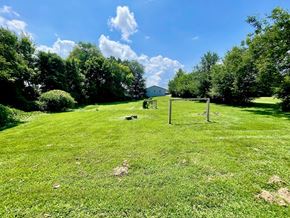 New Albany house for rent - A grassy field with a swing set and trees in the background.
