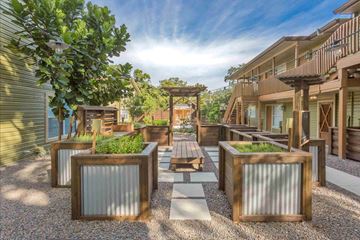 Tampa apartment for rent - A sunny day in a courtyard with a wooden bench and a table.