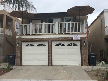 Newport Beach apartment for rent - A two-car garage is in front of a house.