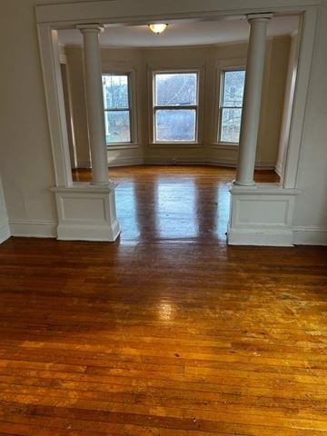 Syracuse apartment for rent - A room with wooden floors and white columns.