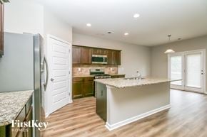 Winder house for rent - A kitchen with a granite countertop and wooden floors.