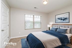 Winder house for rent - A bedroom with a large bed and a painting on the wall.