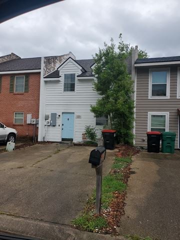 Lafayette house for rent - A grey house with a blue door is in front of a red brick house.