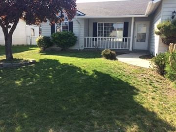 Post Falls house for rent - A white house with a tree in front of it.