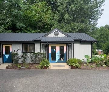 Lake Lure apartment for rent - A small building with a black roof and a blue door.