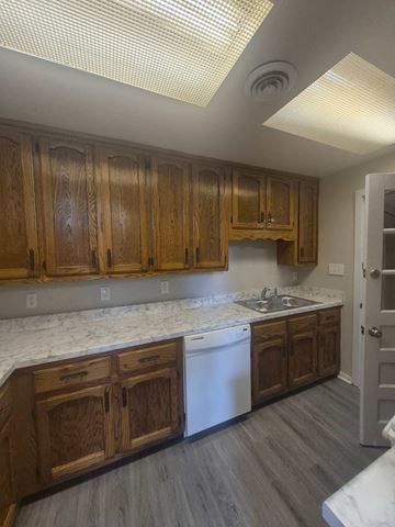 Clarksville house for rent - A kitchen with wooden cabinets and a white dishwasher.