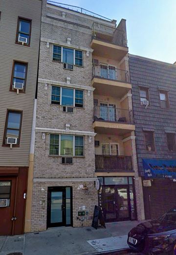 Brooklyn apartment for rent - A building with a balcony and a car parked in front.