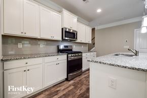 Canton house for rent - A kitchen with white cabinets and a granite countertop.
