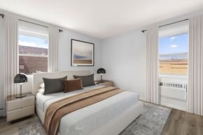 Bayonne apartment for rent - A bedroom with a large bed and a window overlooking a beach.