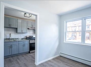 Bayonne apartment for rent - A kitchen with a sink, stove, and cabinets is visible through a doorway.