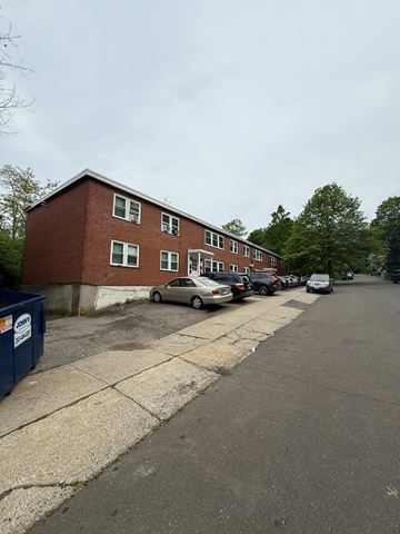 New Haven apartment for rent - A red brick building with a parking lot in front.