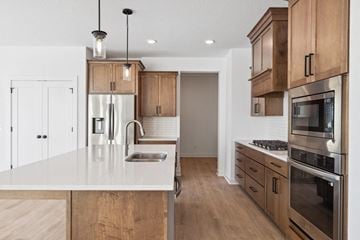 Lake Elmo house for rent - A modern kitchen with wooden cabinets and stainless steel appliances.