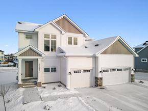 Lake Elmo house for rent - A house with a white garage door is surrounded by snow.