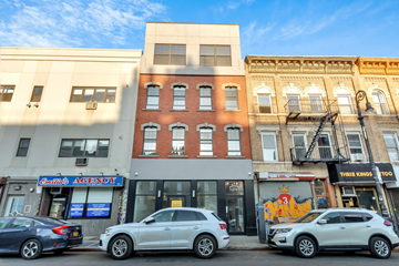 Brooklyn apartment for rent - Cars parked in front of a row of buildings on a sunny day.