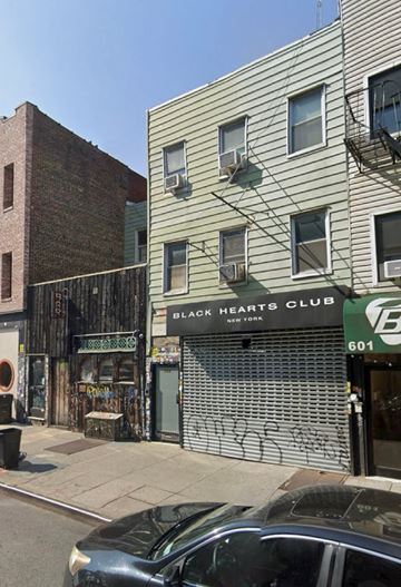 Brooklyn apartment for rent - A car is parked on the street in front of a building with a Black Hearts Club sign.