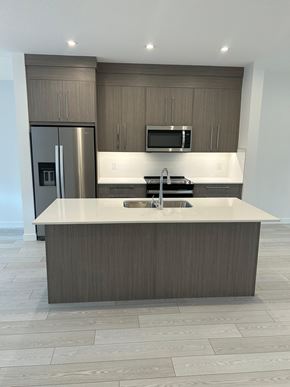 Calgary house for rent - A modern kitchen with a large island and stainless steel appliances.